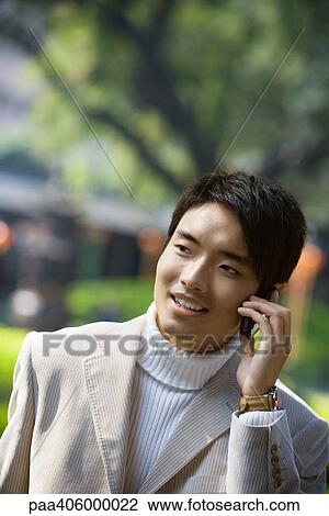 Young man using cell phone View Large Photo Image Stock Image - Young man using cell phone. Fotosearch