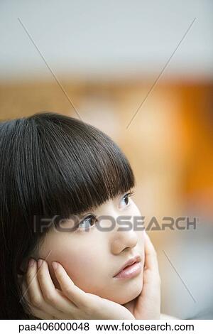 Young woman holding head in hands, looking away, portrait View Large Photo Image Stock Photo - Young woman holding head in hands, looking away, portrait. Fotosearch