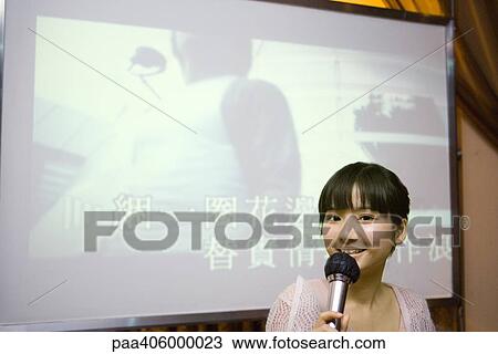 Young woman singing karaoke View Large Photo Image Stock Image - Young woman singing karaoke. Fotosearch