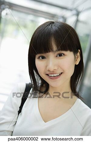 Young woman smiling at camera, head and shoulders, portrait View Large Photo Image Stock Image - Young woman smiling at camera, head and shoulders, portrait. Fotosearch