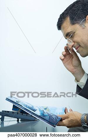 Stock Photo - Businessman looking at comic book. Fotosearch