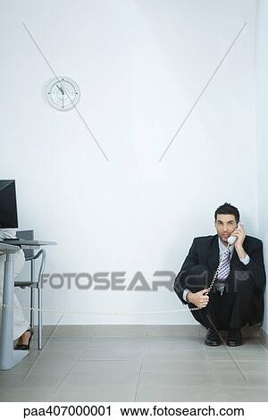 Businessman sitting on floor, in corner, talking on phone View Large Photo Image Stock Image - Businessman sitting on floor, in corner, talking on phone. Fotosearch