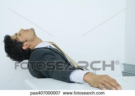 Businessman sitting with head back and eyes closed View Large Photo Image Stock Photo - Businessman sitting with head back and eyes closed. Fotosearch