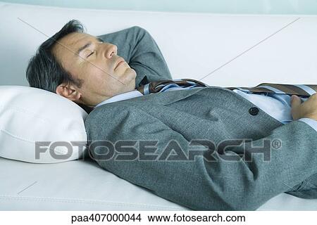 Picture - Businessman sleeping on sofa. Fotosearch
