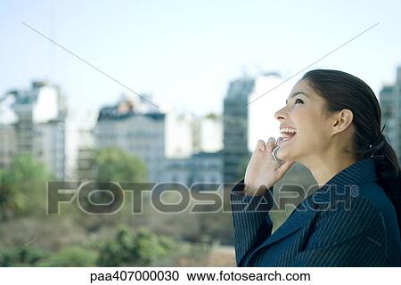 Businesswoman using cell phone, laughing, cityscape in background View Large Photo Image Stock Image - Businesswoman using cell phone, laughing, cityscape in background. Fotosearch