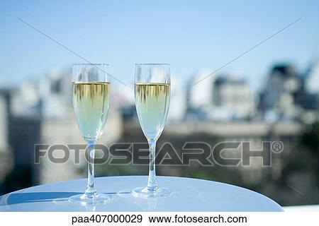 Two glasses of champagne and city skyline View Large Photo Image Stock Photo - Two glasses of champagne and city skyline. Fotosearch