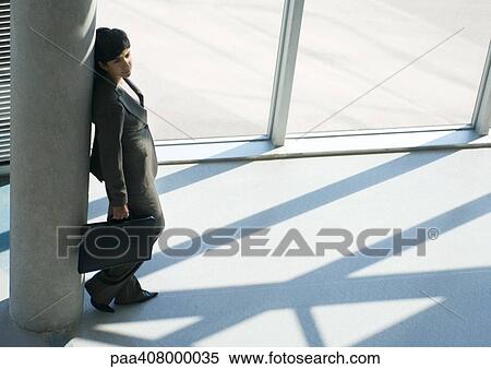 Businesswoman leaning against column, full length, high angle view View Large Photo Image Stock Photography - Businesswoman leaning against column, full length, high angle view. Fotosearch
