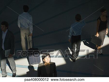 Businesswoman standing with eyes closed in ray of sunlight while people pass by View Large Photo Image Stock Image - Businesswoman standing with eyes closed in ray of sunlight while people pass by. Fotosearch