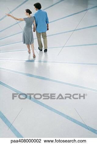 Couple walking, woman pointing, full length, high angle rear view View Large Photo Image Stock Image - Couple walking, woman pointing, full length, high angle rear view. Fotosearch