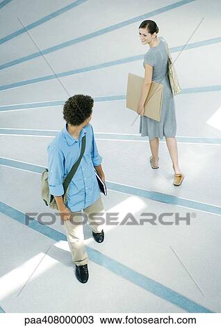 Man and woman looking over shoulders at each other in passing, full length, high angle view View Large Photo Image Stock Image - Man and woman looking over shoulders at each other in passing, full length, high angle view. Fotosearch