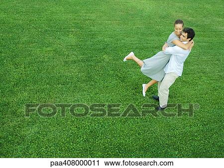 Man swinging woman in his arms, full length, high angle view View Large Photo Image Stock Image - Man swinging woman in his arms, full length, high angle view. Fotosearch