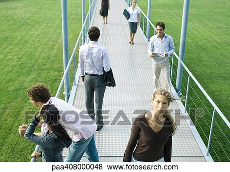 People standing and walking on walkway View Large Photo Image Stock Photo - People standing and walking on walkway. Fotosearch