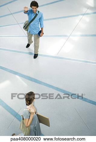 Teenage boy wearing messenger bag waving to female friend, full length, high angle view View Large Photo Image Stock Image - Teenage boy wearing messenger bag waving to female friend, full length, high angle view. Fotosearch