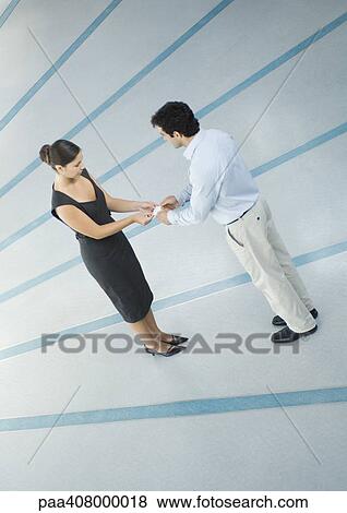 Woman and man exchanging business card, full length, high angle view View Large Photo Image Stock Photo - Woman and man exchanging business card, full length, high angle view. Fotosearch