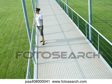 Woman standing on walkway, full length, high angle view View Large Photo Image Stock Image - Woman standing on walkway, full length, high angle view. Fotosearch