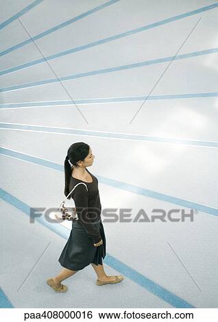 Stock Photograph - Woman walking, full length, high angle view. Fotosearch