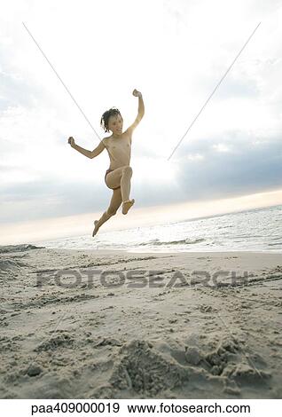 Stock Photo - Child jumping on beach. Fotosearch