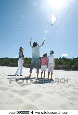 Picture - Family flying kite on beach. Fotosearch