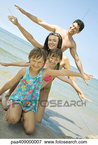 Family on beach lined up with arms out View Large Photo Image Stock Photo - Family on beach lined up with arms out. Fotosearch
