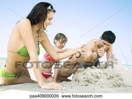 Family playing in sand together on beach View Large Photo Image Stock Photography - Family playing in sand together on beach. Fotosearch
