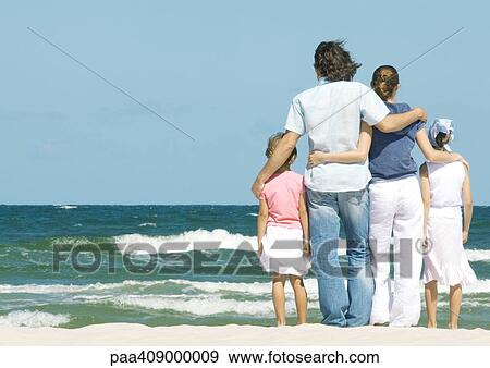 Family standing next to surf, facing ocean, rear view View Large Photo Image Stock Photo - Family standing next to surf, facing ocean, rear view. Fotosearch