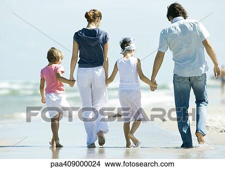 Family walking on beach, rear view, full length View Large Photo Image Picture - Family walking on beach, rear view, full length. Fotosearch