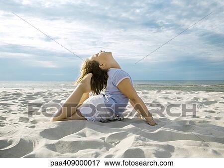 Stock Photo - Girl doing yoga pose on beach. Fotosearch