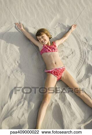 Girl making angel in sand on beach, high angle view View Large Photo Image Stock Image - Girl making angel in sand on beach, high angle view. Fotosearch