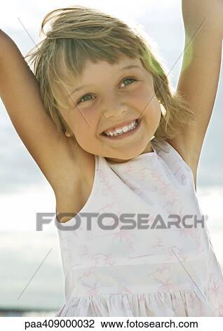 Girl raising arms, smiling, portrait View Large Photo Image Stock Image - Girl raising arms, smiling, portrait. Fotosearch