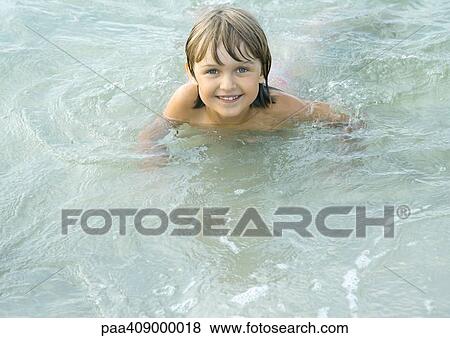 Girl wading in shallow water, looking at camera View Large Photo Image Stock Photo - Girl wading in shallow water, looking at camera. Fotosearch