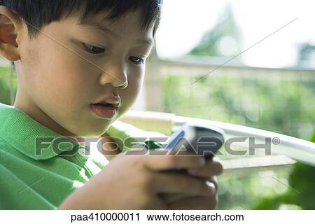 Boy holding cell phone, close-up View Large Photo Image Stock Image - Boy holding cell phone, close-up. Fotosearch