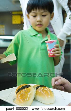 Boy looking at tray of food View Large Photo Image Stock Image - Boy looking at tray of food. Fotosearch