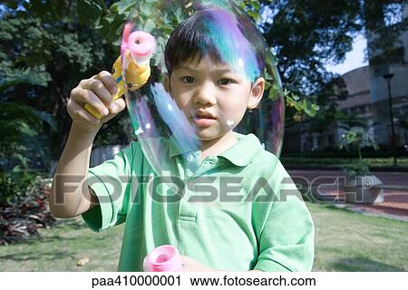 Boy making bubbles with bubble wand View Large Photo Image Stock Image - Boy making bubbles with bubble wand. Fotosearch