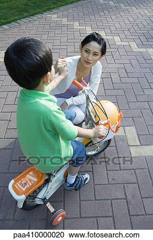 Boy on bike with training wheels and mother View Large Photo Image Stock Image - Boy on bike with training wheels and mother. Fotosearch