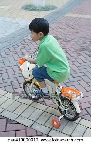 Boy riding bike with training wheels View Large Photo Image Stock Photo - Boy riding bike with training wheels. Fotosearch