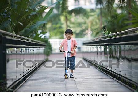 Boy riding scooter View Large Photo Image Stock Image - Boy riding scooter. Fotosearch