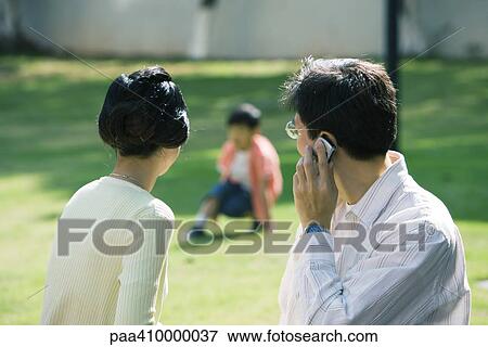 Parents turned toward son, man using cell phone View Large Photo Image Stock Photo - Parents turned toward son, man using cell phone. Fotosearch