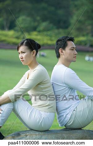 Stock Photograph - Couple sitting back to back. Fotosearch
