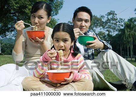 Family eating meal in the park View Large Photo Image Stock Image - Family eating meal in the park. Fotosearch
