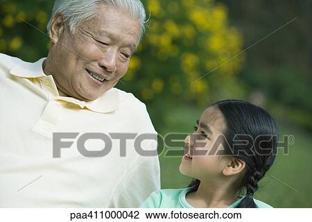 Girl and grandfather, smiling at each other View Large Photo Image Stock Image - Girl and grandfather, smiling at each other. Fotosearch