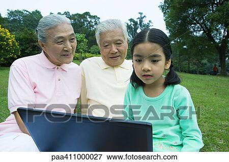 Girl and grandparents using laptop View Large Photo Image Stock Photo - Girl and grandparents using laptop. Fotosearch