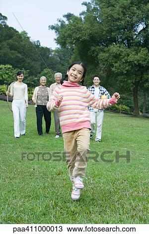 Stock Image - Girl dancing while parents and grandparents watch in background. Fotosearch