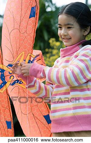 Girl holding kite View Large Photo Image Stock Photograph - Girl holding kite. Fotosearch