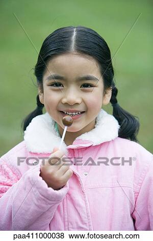 Girl holding lollipop, portrait View Large Photo Image Stock Photo - Girl holding lollipop, portrait. Fotosearch