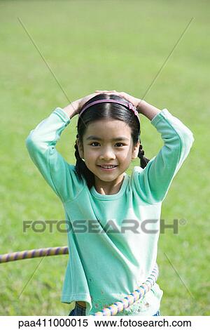 Girl playing with plastic hoop, smiling at camera View Large Photo Image Stock Photography - Girl playing with plastic hoop, smiling at camera. Fotosearch
