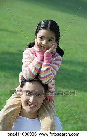 Girl sitting on father's shoulders, portrait View Large Photo Image Stock Image - Girl sitting on father's shoulders, portrait. Fotosearch