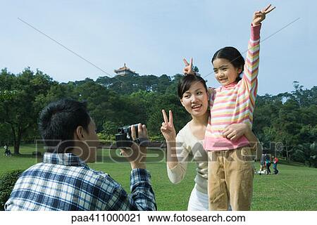 Man videotaping daughter and wife in park View Large Photo Image Stock Image - Man videotaping daughter and wife in park. Fotosearch
