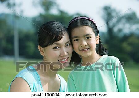 Stock Image - Mother and daughter, cheek to cheek, portrait. Fotosearch