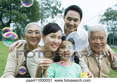 Three generation family in park blowing bubbles, portrait View Large Photo Image Stock Image - Three generation family in park blowing bubbles, portrait. Fotosearch