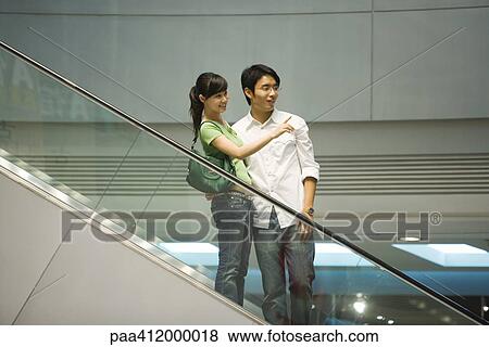 Stock Photo - Couple on escalator. Fotosearch